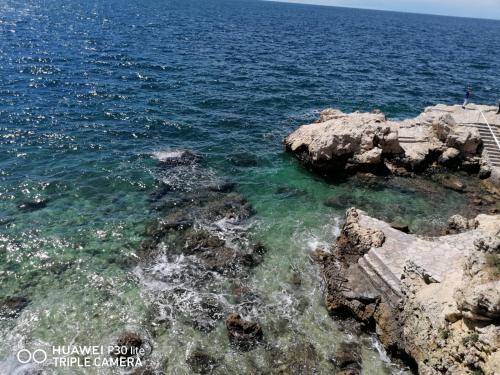 a view of the ocean with rocks in the water at Apartment Borna in Pazin