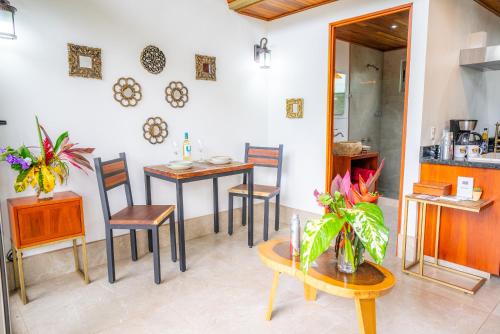a dining room with tables and chairs and a kitchen at Sloth Premium Riverfront Jungle Villa with Jacuzzi and Pool in Uvita