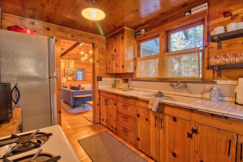 una cucina con mobili in legno e un frigorifero in acciaio inossidabile di Ray's Dear Cottage a Wrightwood