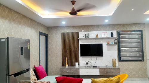 a living room with a couch and a ceiling fan at Vizag Venya Vihar a 2BHK Deluxe Furnished HomeStays in Visakhapatnam