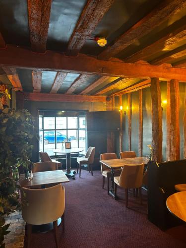 a restaurant with tables and chairs in a room at The Limes Bar and Hotel in Needham Market