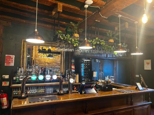 a bar in a pub with a mirror and lights at The Limes Bar and Hotel in Needham Market