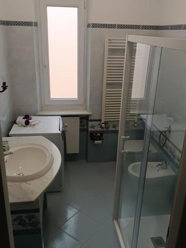 a white bathroom with a sink and a shower at 2 Mimose in Recco