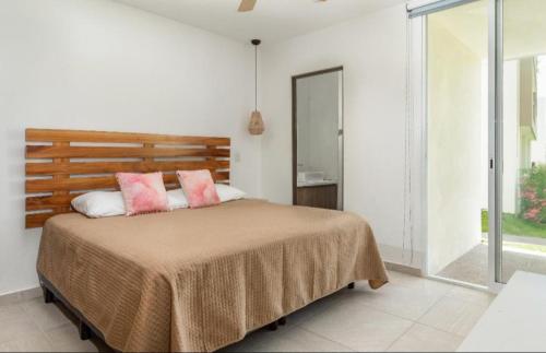 a bedroom with a bed with two pink pillows at Serenity Escape in Mezcales