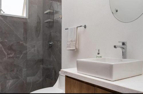 a white bathroom with a sink and a shower at Serenity Escape in Mezcales