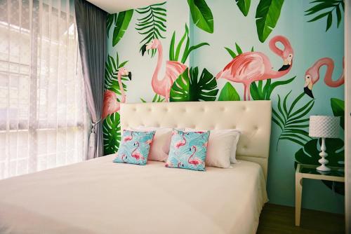 una camera da letto con un letto con fenicotteri sul muro di Siritatta villa a Chiang Mai