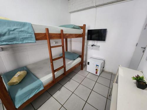 two bunk beds in a small room with a television at Casa Recife Pousada in Recife