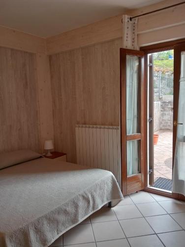 Un dormitorio con una cama y una puerta corrediza de vidrio. en Casa Vacanze L'Agrifoglio, en Castel di Sangro