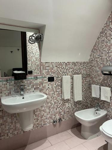 a bathroom with a sink and a toilet and a mirror at B&B La Dimora Di Nettuno in Naples