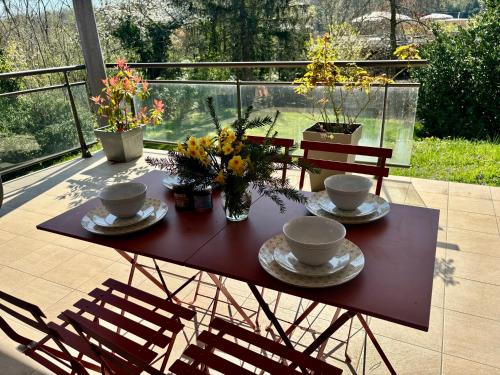 une table avec des tasses, des soucoupes et des fleurs sur une terrasse dans l'établissement Superbe et au calme - vue zoo - 3 chambres, à Mulhouse