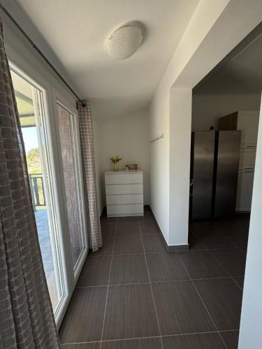 a kitchen with a large window and a refrigerator at Apartman Đokić 3 in Bale