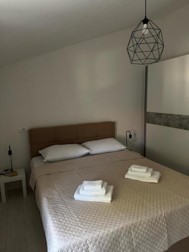 a bedroom with a bed with two towels on it at Apartman Đokić 3 in Bale