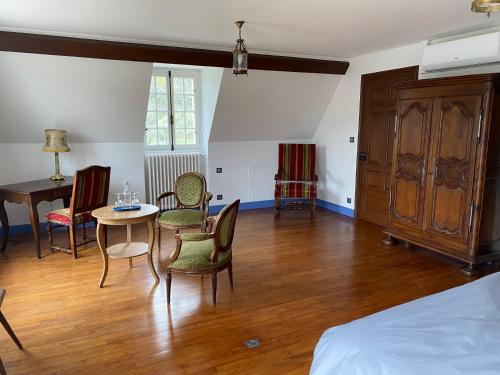 a room with a bed and a table and chairs at Longue Vue en Arbois in Arbois
