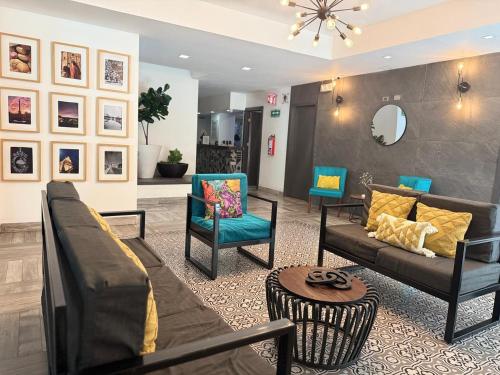 a living room with a couch and chairs and a mirror at MCI HOTEL in San Juan de los Lagos