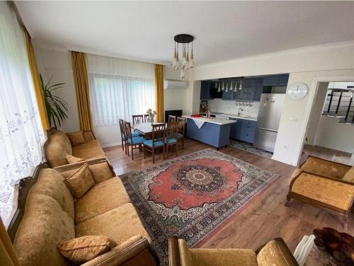 a living room with a couch and a table and a kitchen at Ömer bey konak in Akcaabat