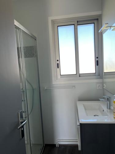 a bathroom with a glass shower and a sink at Maison rénovée avec garage et jardin, proche centre ville - La Tremblade in La Tremblade