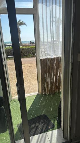 une porte ouverte avec vue sur la plage dans l'établissement Appartement front de mer, à Canet