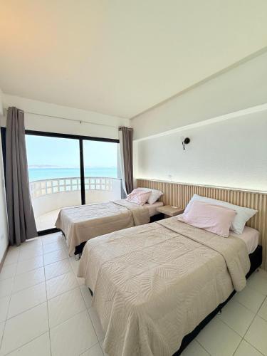 zwei Betten in einem Zimmer mit Meerblick in der Unterkunft Apto Playa Lido, DH, 2B, de Lux in Puerto La Cruz
