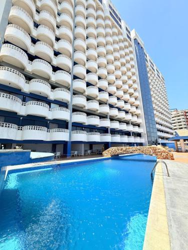 ein Hotel mit einem Swimmingpool vor einem Gebäude in der Unterkunft Apto Playa Lido, DH, 2B, de Lux in Puerto La Cruz