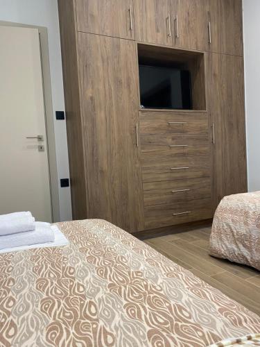 a bedroom with a large wooden cabinet with a television at Mountain View Apartment in Pramanta