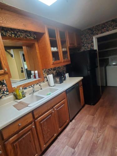 a kitchen with a sink and a black refrigerator at Spacious ranch home near Stone Mountain Park in Stone Mountain