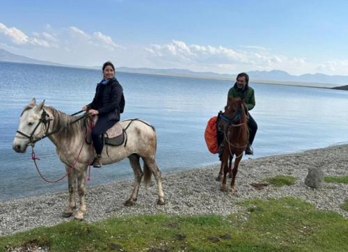 DzhangyarykにあるGuest House Nukuraの水辺の浜辺で馬に乗る女性2人