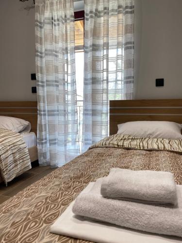 a bedroom with a bed with two towels on it at Mountain View Apartment in Pramanta
