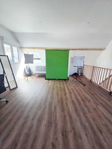 Cette chambre vide est dotée d'un mur vert et de parquet. dans l'établissement Salle de Réunion Proche Rouen, à Saint-Léger-du-Bourg-Denis