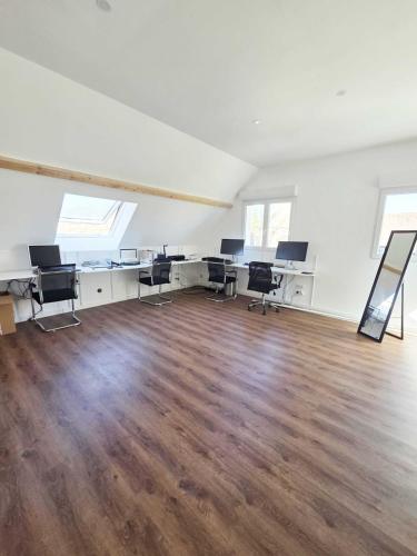 un bureau vide avec des bureaux et des chaises dans une pièce dans l'établissement Salle de Réunion Proche Rouen, à Saint-Léger-du-Bourg-Denis