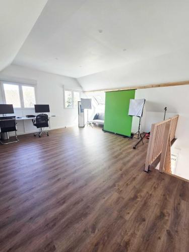 Cette chambre vide est dotée de parquet et d'un mur vert. dans l'établissement Salle de Réunion Proche Rouen, à Saint-Léger-du-Bourg-Denis