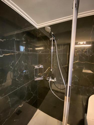 a bathroom with a shower with a black marble wall at Mountain View Apartment in Pramanta