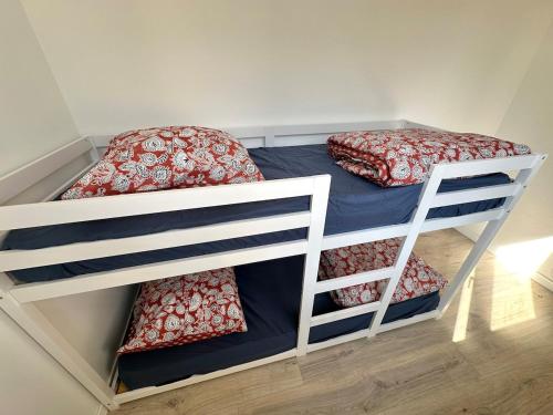 due letti a castello in una piccola stanza con tre letti e tre letti a castello in una piccola stanza con un'altra di tre mesi di vita e di vita. di Appartement ultra lumineux à Berck-Plage pour 6 personnes a Berck-sur-Mer
