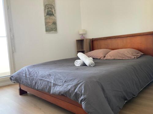 une chambre avec un lit avec deux serviettes dessus dans l'établissement Appartement 90m2, 3 chambres, 6 personnes, proche Paris, à Asnières-sur-Seine