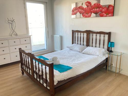 - une chambre avec un lit en bois et une commode dans l'établissement Appartement 90m2, 3 chambres, 6 personnes, proche Paris, à Asnières-sur-Seine