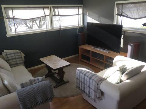 a living room with a couch and a tv at Sara's Fjord View House in Stadlandet