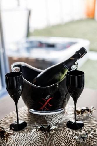 - une bouteille de vin dans un seau sur une table avec deux verres dans l'établissement Love-Room BreakyWell, à Rémelfang