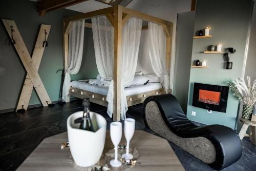 une chambre avec un lit et deux chaises et une cheminée dans l'établissement Love-Room BreakyWell, à Rémelfang