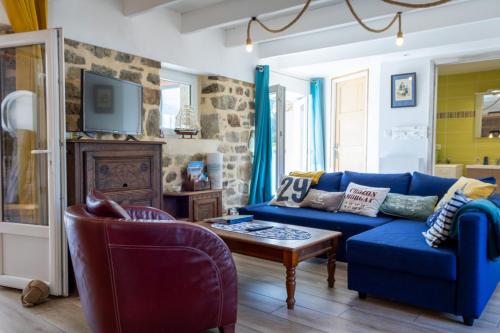 een woonkamer met een blauwe bank en een tafel bij Ty Kichen Mor - campagne - wifi in Crozon
