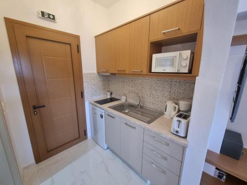 een kleine keuken met een spoelbak en een magnetron bij Olive Grove View in Skiathos-stad