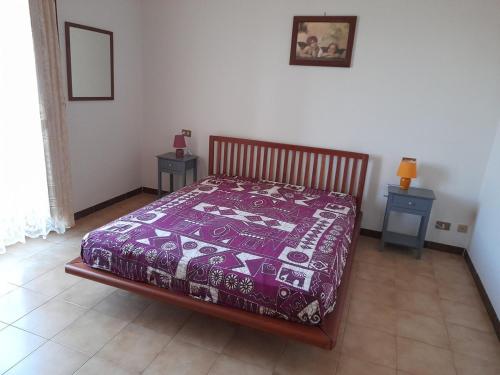 a bedroom with a bed with a purple blanket on it at Il Fossatello in Scandriglia