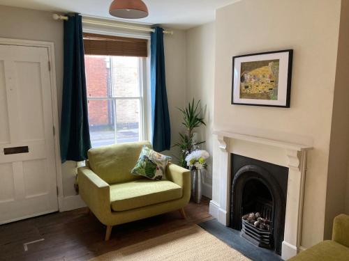 a living room with a chair and a fireplace at Painters Cottage, Grade II Listed, Salisbury in Salisbury