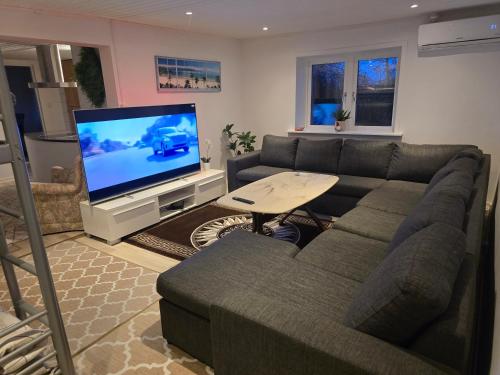 a living room with a couch and a flat screen tv at Relax Place in Svalöv