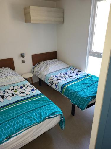 deux lits assis dans une pièce avec une fenêtre dans l'établissement Camping Tikayan LES CIGALES, au Muy