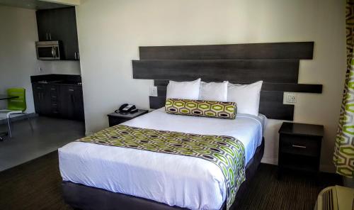 a hotel room with a large bed with a headboard at Jewel City Inn in Glendale