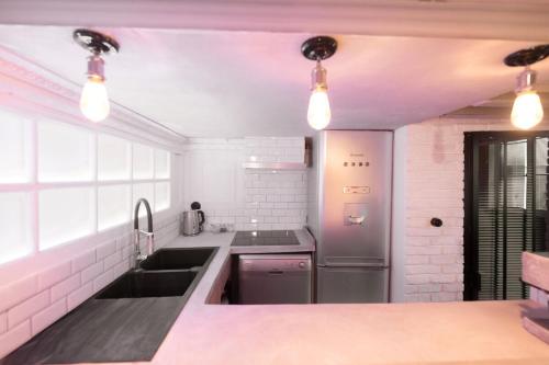 une cuisine avec un évier et une cuisinière dans l'établissement Artist's Mini Loft - Marais, à Paris