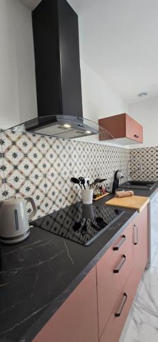 - une cuisine avec un comptoir noir et une cuisinière dans l'établissement La Maison Chehaa, à Bias