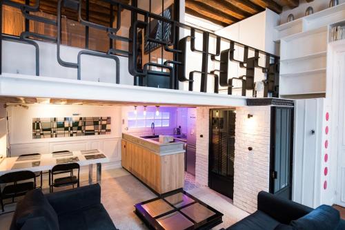 une cuisine et un salon avec un canapé et une table dans l'établissement Artist's Mini Loft - Marais, à Paris