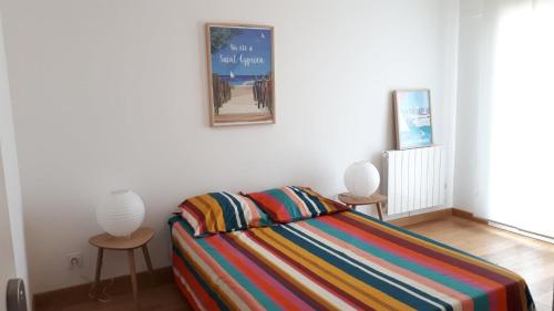 - une chambre avec un lit avec deux tables et une photo sur le mur dans l'établissement Maison familiale Saint Cyprien, à Saint-Cyprien