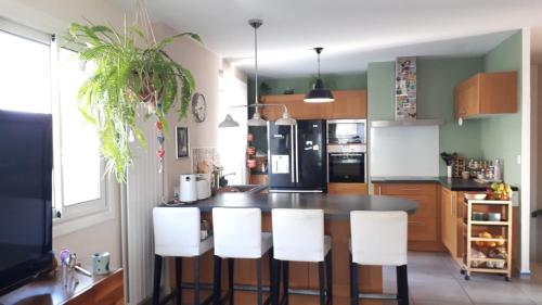 - une cuisine avec une table et des chaises blanches dans l'établissement Maison familiale Saint Cyprien, à Saint-Cyprien