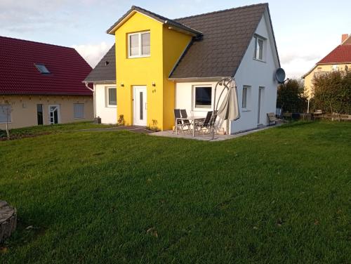una casa gialla e bianca con cortile di Familienfreundliches, Ruhiges Ferienhaus a Boiensdorf